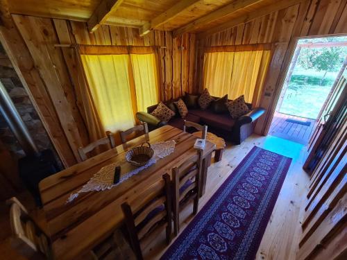 a living room with a wooden table and a couch at Cabañas GAROVE in Panguipulli