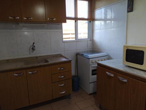 uma pequena cozinha com um lavatório e um micro-ondas em Casa cómoda en Barra del Chuy, Uruguay em Barra del Chuy