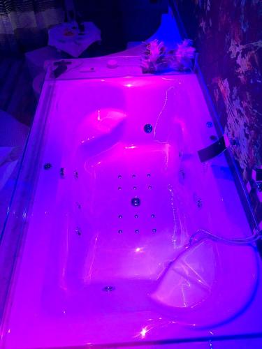 a red bathtub lit up with a pink light at Assisi Luxury SPA Suite Superior in Assisi