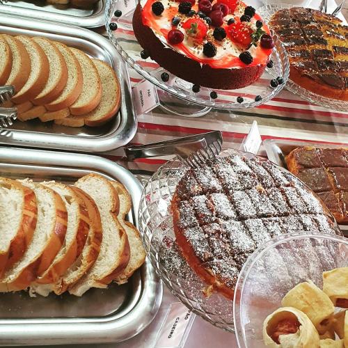 a table with trays of cakes and pies and desserts at Hotel Costa Dalpiaz in Torres