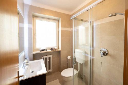 uma casa de banho com um WC, um lavatório e um chuveiro em Ferienwohnung am Kalterer See in Südtirol em Caldaro