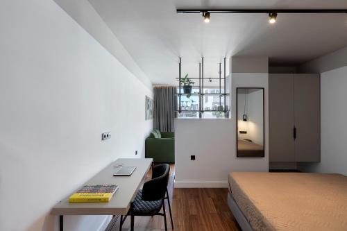 a bedroom with a bed and a table and chairs at The Athenians Art Apartments in Athens