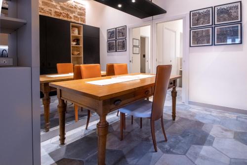 uma sala de jantar com uma mesa de madeira e cadeiras em Zisa Suite em Palermo