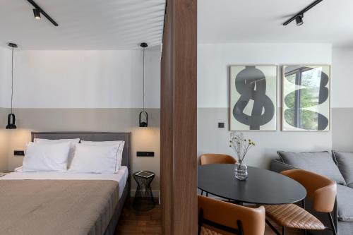 a bedroom with a bed and a table and a couch at The Athenians Art Apartments in Athens