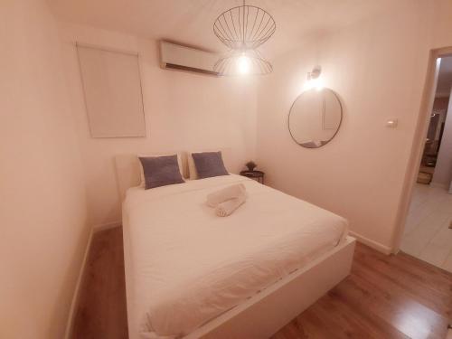 a bedroom with a bed with white sheets and a mirror at Eilat vacation house דירות נופש אילת in Eilat