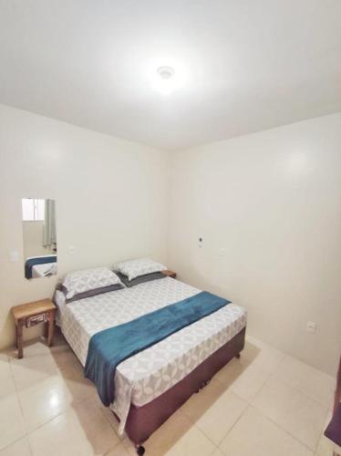 a bedroom with a bed in a white room at Pousada Origin in Guarda do Embaú