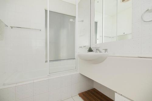 a white bathroom with a sink and a shower at Quarterdeck 20 in Lennox Head