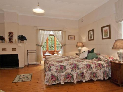 a bedroom with a bed and a fireplace at Hollyoak Cottage in Bowral