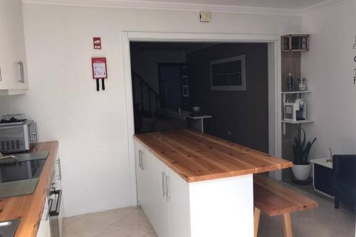 a kitchen with a wooden counter top in a room at #GC House in Ponta Delgada