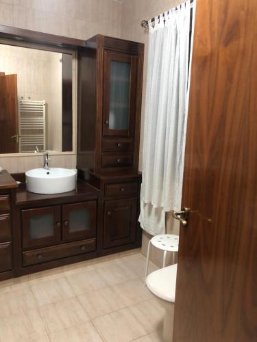 a bathroom with a sink and a toilet and a mirror at Casa Rural La Candelaria in Burujón