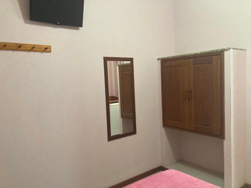 a bathroom with a mirror and a cabinet at Pousada Maravista in Anchieta