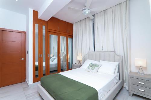 una camera da letto con un grande letto con una coperta verde di Apartamento N1401 Downtown Santo Domingo a Santo Domingo