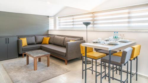 uma sala de estar com um sofá e uma mesa com cadeiras em Midpoint Suites em Fethiye