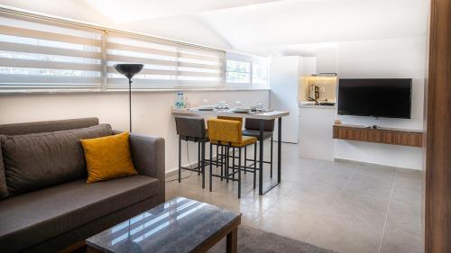 a living room with a couch and a kitchen at Midpoint Suites in Fethiye