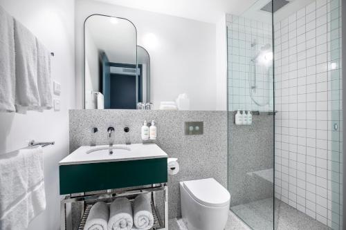 a bathroom with a toilet, sink, and bathtub at Holiday Inn Werribee, an IHG Hotel in Werribee
