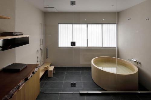 ein großes Bad mit einer Badewanne und einem Waschbecken in der Unterkunft modern ryokan kishi-ke in Kamakura