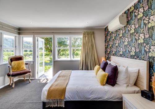 a bedroom with a bed with a floral accent wall at The Farmhouse in Napier