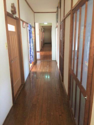 an empty hallway of a building with a wooden floor at Ryokan Mikasaya in Beppu
