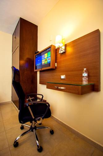 a room with a chair and a television on a wall at Hotel San Miguel, en el Centro - Desayuno Incluido in Tuxtla Gutiérrez