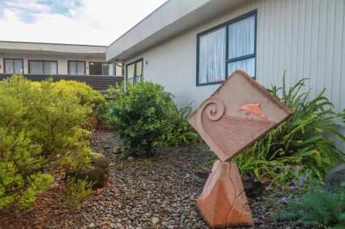 a sign in a garden in front of a house at Fiesta Court Motel in Whanganui