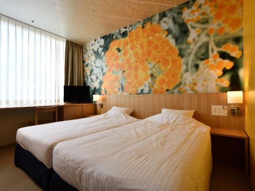 a bedroom with a bed and a painting on the wall at Hotel Art Stay Naha Kokusai-Dori in Naha