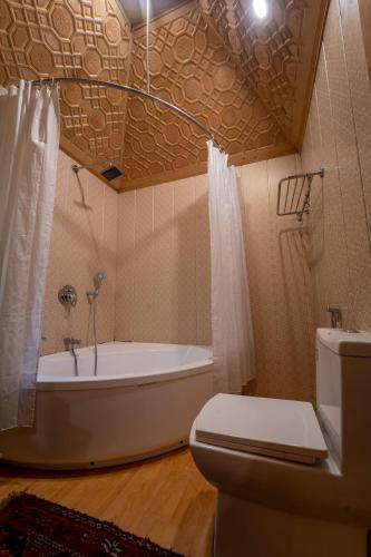 a bathroom with a bath tub and a toilet at Khilona luxury Heritage Houseboats in Srinagar