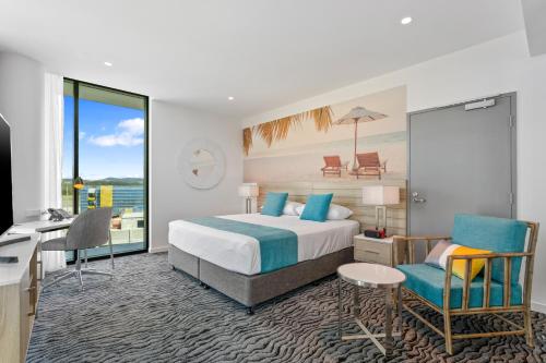 a hotel room with a bed and a desk and chair at Rydges Gold Coast Airport in Gold Coast