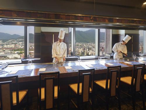two chefs standing at a table in a restaurant at Rihga Royal Hotel Kokura Fukuoka in Kitakyushu