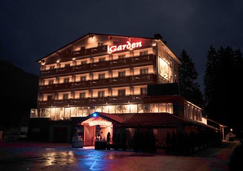 a hotel building with a sign on it at night at Garden Wellness Hotel S in Andalo