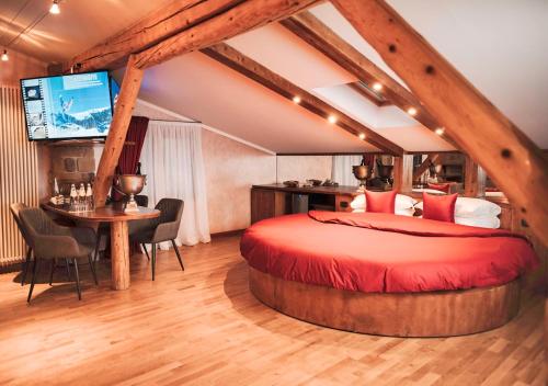 sypialnia z łóżkiem, stołem i telewizorem w obiekcie Garden Wellness Hotel S w Andole