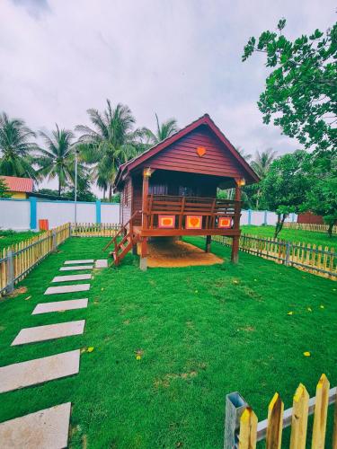 a playground with a small building on the grass at Damnak Borey Resort in Kampot