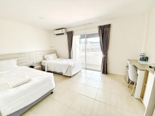 ein Hotelzimmer mit 2 Betten und einem Fenster in der Unterkunft Mystays Phuket SHA Plus in Phuket