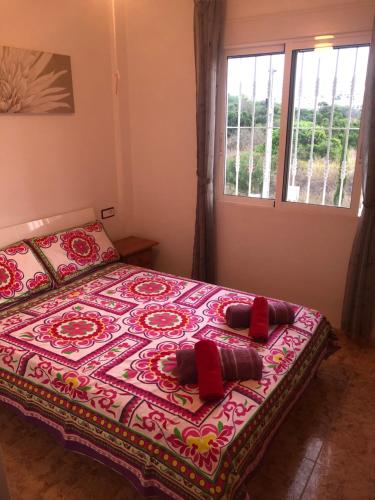 オリフエラ・コスタにあるSaint James Park upstairsのベッドルーム1室(赤い枕のベッド1台付)