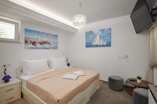 um quarto branco com uma cama e uma televisão em Rhea Silvia em Dubrovnik