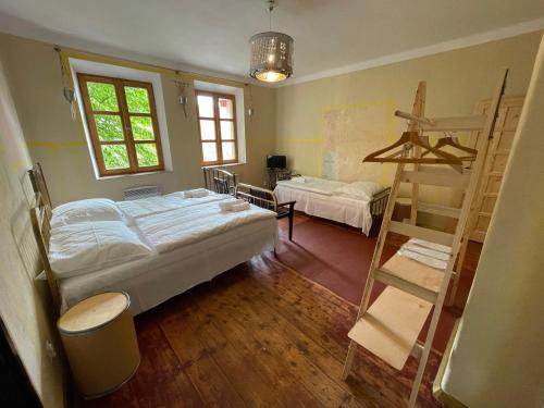 a bedroom with a bed and a ladder in it at HARABURDI® Recyclart Hotel in Kostelec nad Orlicí