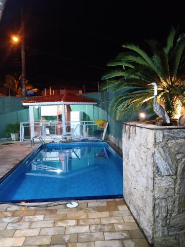 een zwembad in een resort 's nachts bij Casa 100mtrs do mar com piscina aquecida in Praia Grande