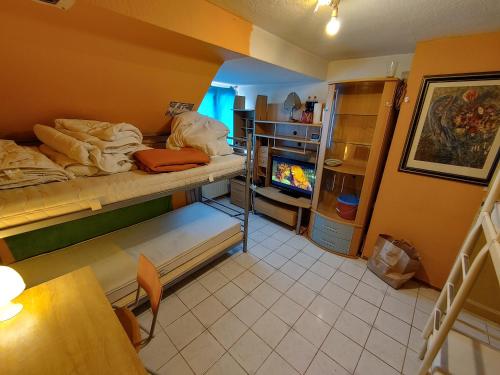 Cette chambre comprend un lit, une table et une télévision. dans l'établissement PrivateRoomsAE, à Essen