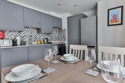 a kitchen with a table with chairs and wine glasses at Finest Retreats - Belle House, Apt 4 in Filey