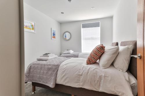 1 dormitorio con 1 cama con paredes blancas y espejo en Finest Retreats - Belle House, Apt 6, en Filey