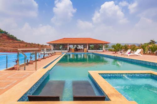 una grande piscina con gazebo di La Palm by StayVista - Mountain-view villa, boasting a spacious pool, Gym, Indoor games, Basketball court & A lush lawn with a gazebo a Lonavala