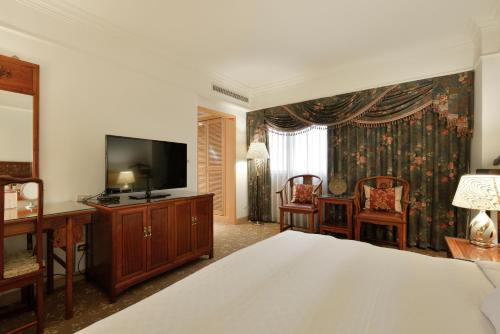 a bedroom with a bed and a flat screen tv at Hotel Sunshine in Kaohsiung