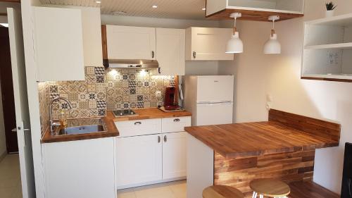 une cuisine avec des armoires blanches et un comptoir en bois dans l'établissement Studio Bandol Centre 2 étoiles idéal emplacement, à Bandol