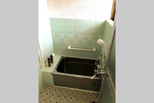 W łazience znajduje się wanna z umywalką. w obiekcie Villa Hineno w mieście Izumisano
