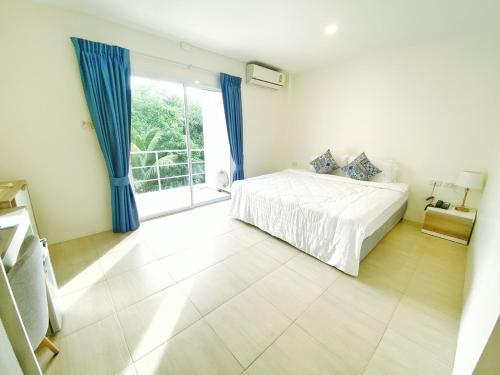 a bedroom with a bed and a large window at Mystays Phuket SHA Plus in Phuket Town