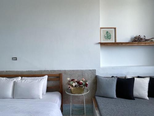 a bedroom with two beds and a table with flowers at 8 Door老宅民宿 in Hengchun