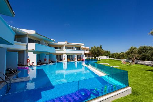 a large swimming pool in front of a house at Lydia Maris Resort & Spa in Kolymbia