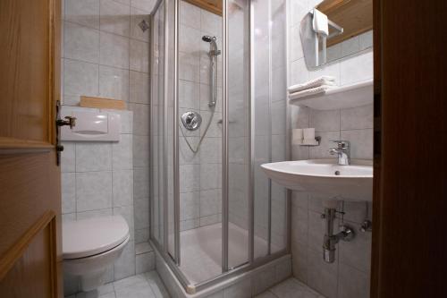 Un baño con ducha, inodoro y lavabo. en Hotel Eckartauerhof, en Mayrhofen