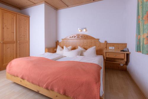 Un dormitorio con una cama grande con una manta roja. en Hotel Eckartauerhof, en Mayrhofen