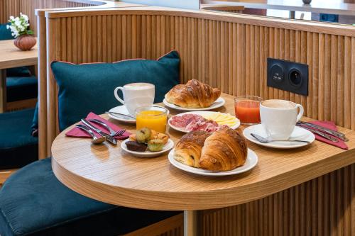 - une table avec des assiettes de croissants et des tasses de café dans l'établissement O.Lysée Hotel, à Paris