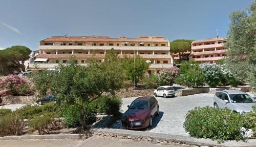 een parkeerplaats met auto's voor een gebouw bij Residence Cala Chiesa in La Maddalena